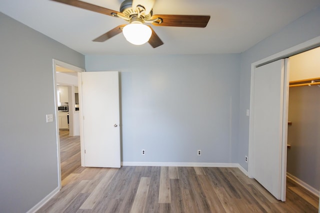 unfurnished bedroom featuring a ceiling fan, a closet, baseboards, and wood finished floors