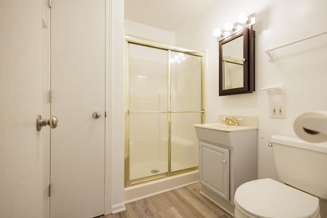 full bath with toilet, a shower stall, wood finished floors, and vanity