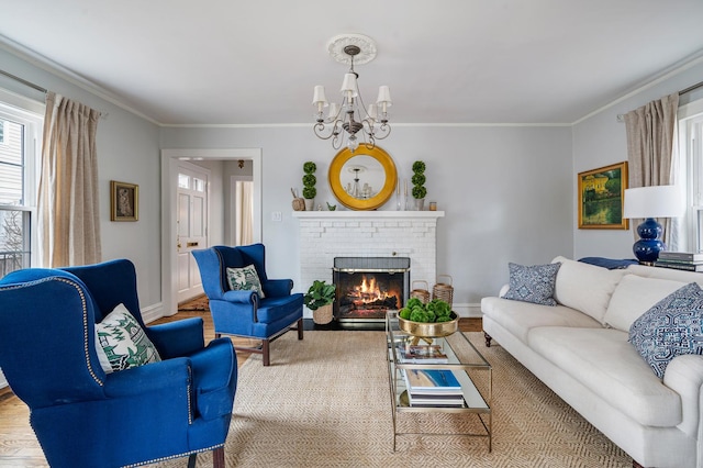 living area with crown molding, an inviting chandelier, a brick fireplace, wood finished floors, and baseboards