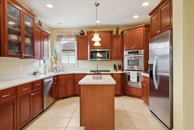 kitchen featuring light tile patterned floors, a kitchen island, stainless steel appliances, and light countertops