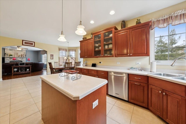 kitchen with dishwasher, a center island, light countertops, pendant lighting, and a sink