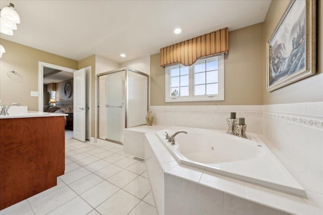 ensuite bathroom with connected bathroom, a tub with jets, tile patterned floors, vanity, and a shower stall