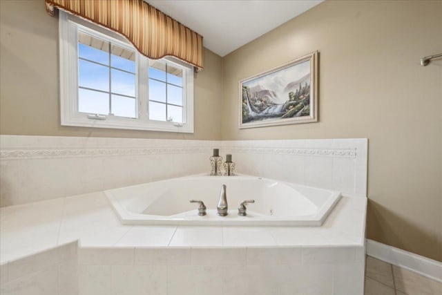 bathroom with baseboards, a bath, and tile patterned floors