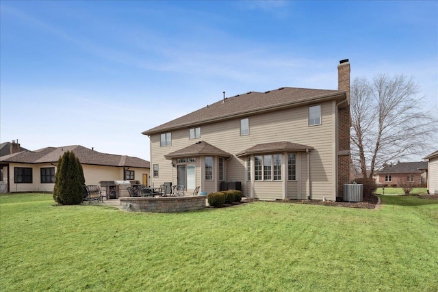 back of property featuring a yard, a patio, a chimney, and central AC unit