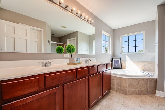 full bath with a bath, tile patterned flooring, double vanity, and a sink