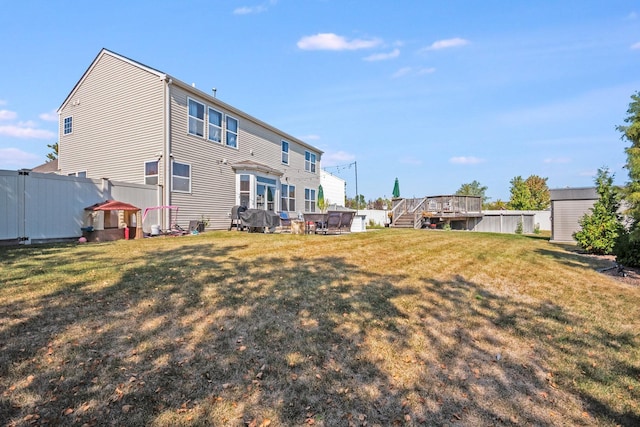 rear view of property featuring fence and a lawn