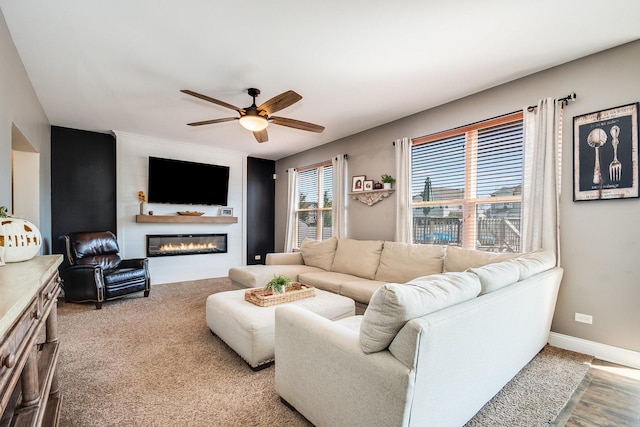 living room with a large fireplace, baseboards, and a ceiling fan