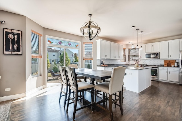 dining area featuring baseboards, a chandelier, and dark wood-style flooring