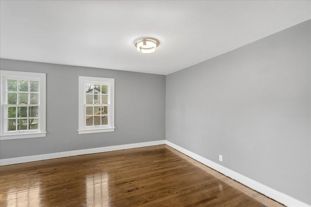 unfurnished room featuring baseboards and wood finished floors