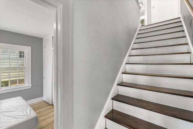 staircase featuring baseboards and wood finished floors