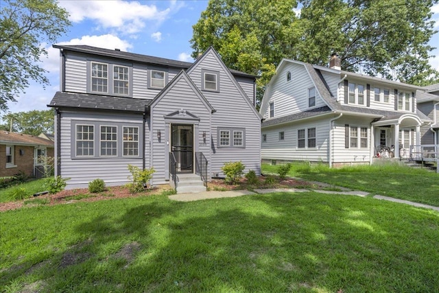 view of front facade featuring a shingled roof, a chimney, and a front lawn