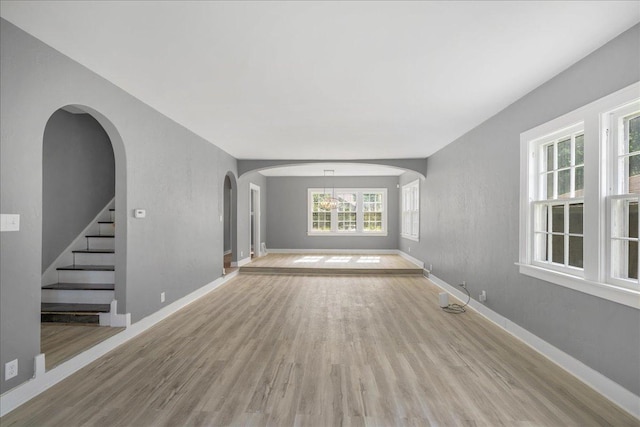 1055 S Myrtle Ave, Kankakee, IL 60901 - unfurnished room with light wood-style floors, arched walkways, and stairs