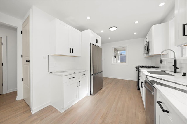 kitchen with stainless steel appliances, a sink, backsplash, and light stone countertops