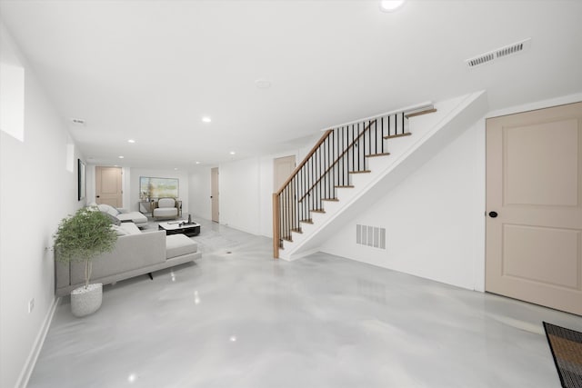 unfurnished living room featuring stairs, finished concrete floors, visible vents, and recessed lighting