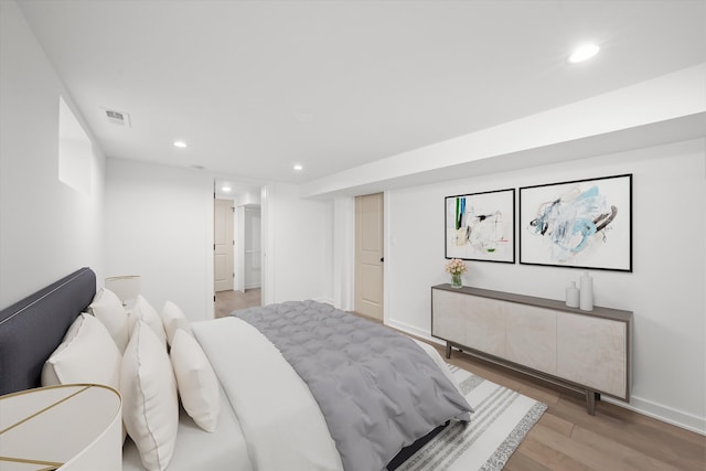 bedroom with light wood-style flooring, visible vents, baseboards, and recessed lighting