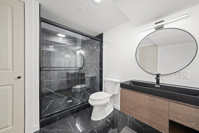 bathroom featuring marble finish floor, a marble finish shower, toilet, vanity, and baseboards