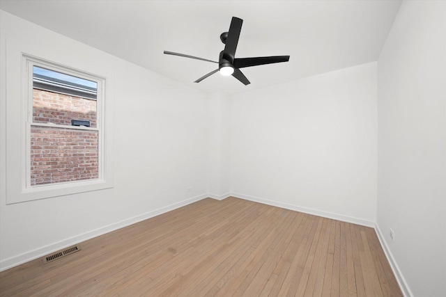 unfurnished room with ceiling fan, light wood finished floors, visible vents, and baseboards