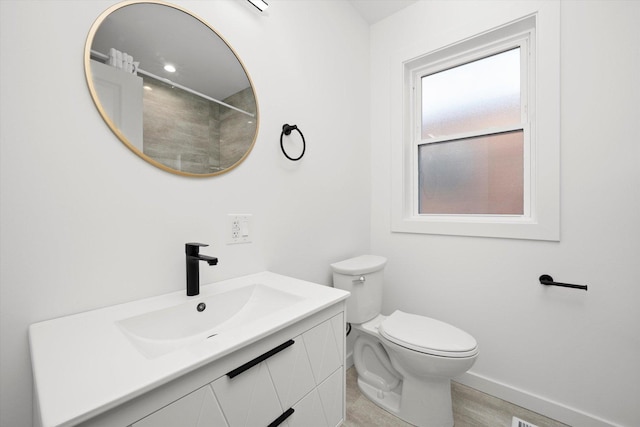 full bath with vanity, toilet, and baseboards