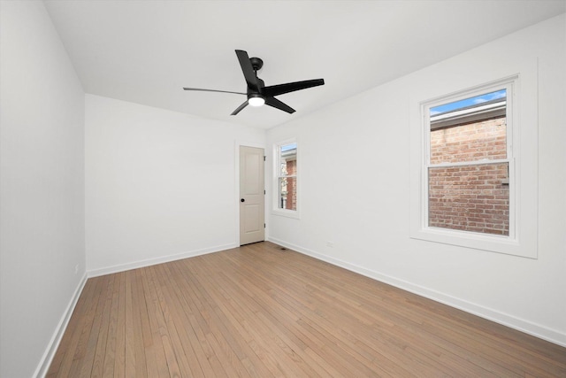 empty room with light wood-type flooring, ceiling fan, and baseboards