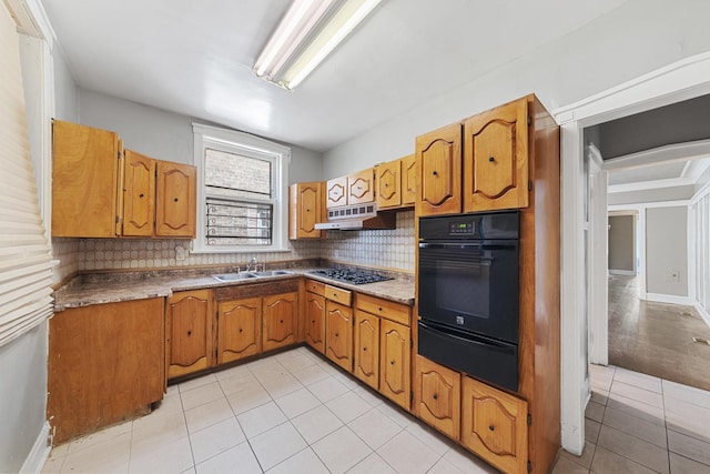 kitchen featuring oven, under cabinet range hood, a sink, backsplash, and a warming drawer