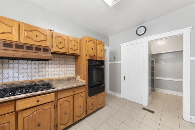 kitchen featuring light tile patterned floors, tasteful backsplash, range hood, black appliances, and a warming drawer