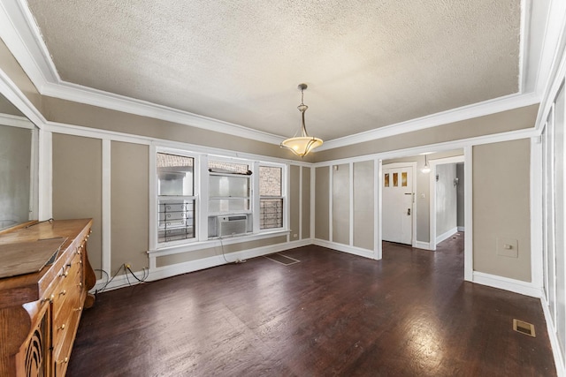 unfurnished dining area with a textured ceiling, cooling unit, visible vents, dark wood finished floors, and crown molding