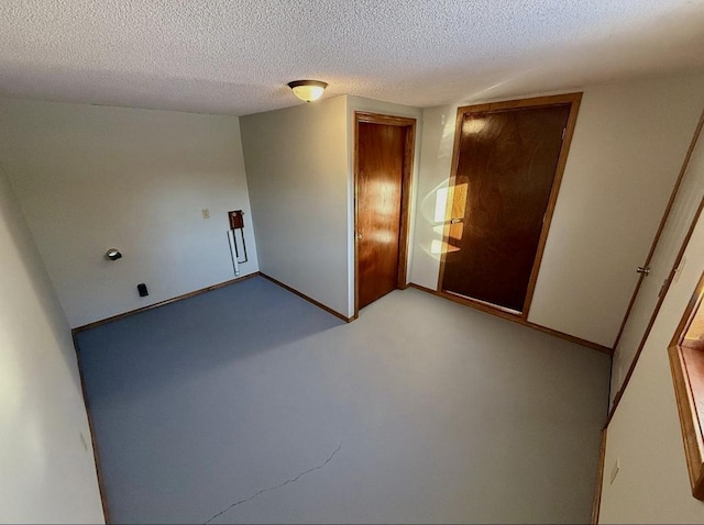 empty room featuring baseboards and a textured ceiling