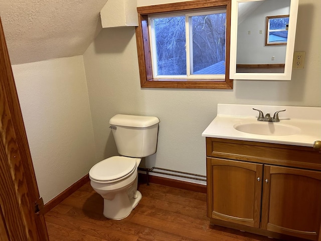 half bath featuring baseboards, lofted ceiling, toilet, wood finished floors, and vanity