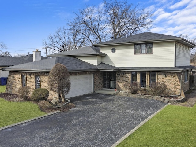 view of front of home with an attached garage, driveway, a front yard, and brick siding