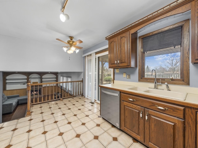 kitchen with light floors, light countertops, stainless steel dishwasher, a ceiling fan, and a sink