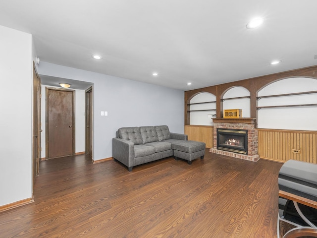 living room featuring wainscoting, a fireplace, wood finished floors, and recessed lighting