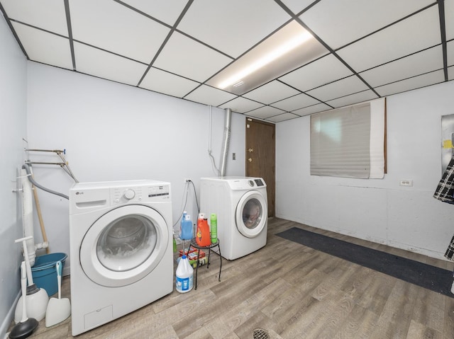 laundry area with laundry area, wood finished floors, and washing machine and clothes dryer