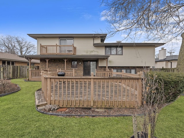 rear view of property with a yard, brick siding, fence, and a wooden deck