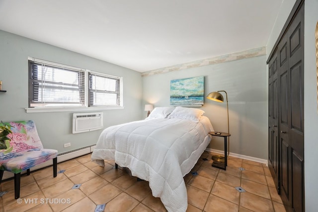 bedroom with a wall unit AC, light tile patterned floors, baseboards, and a baseboard radiator