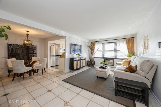 living area featuring light tile patterned flooring, baseboards, and a chandelier