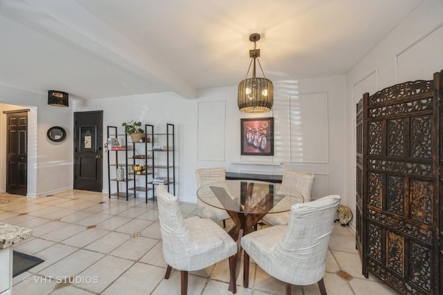 dining space with baseboards, light tile patterned flooring, and a decorative wall