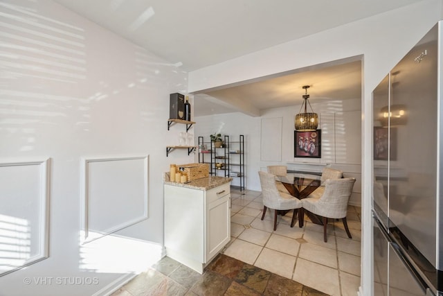 bar featuring hanging light fixtures and freestanding refrigerator