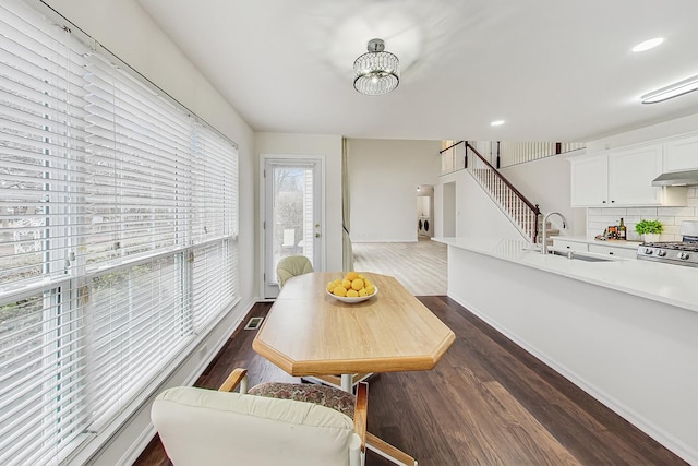 dining space with an inviting chandelier, visible vents, stairway, and dark wood-style flooring