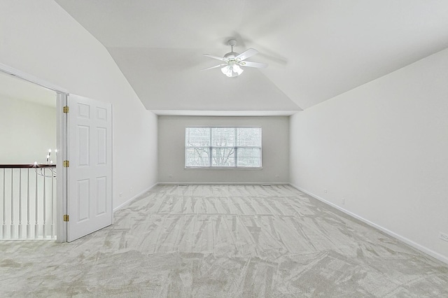 unfurnished room featuring lofted ceiling, carpet, ceiling fan, and baseboards