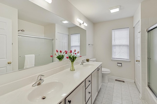 full bathroom featuring tile patterned flooring, a shower with door, a sink, and toilet