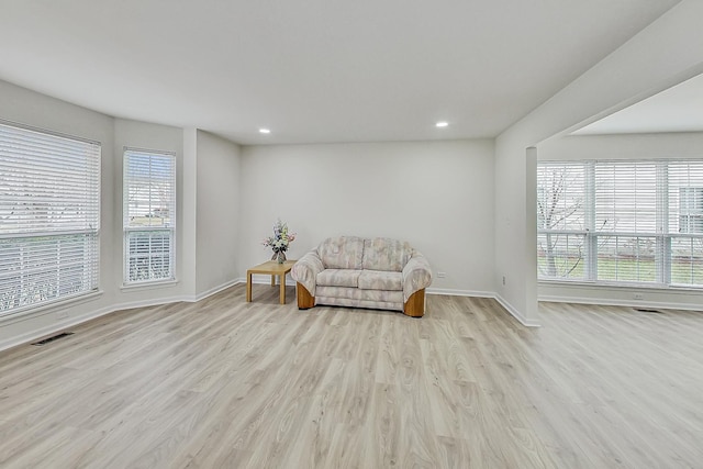 living area featuring recessed lighting, visible vents, baseboards, and wood finished floors