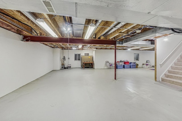 unfinished basement featuring stairway and visible vents