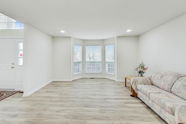 living room featuring recessed lighting, light wood-style flooring, and baseboards