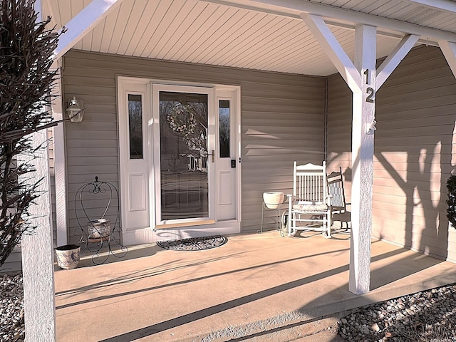 view of exterior entry featuring covered porch