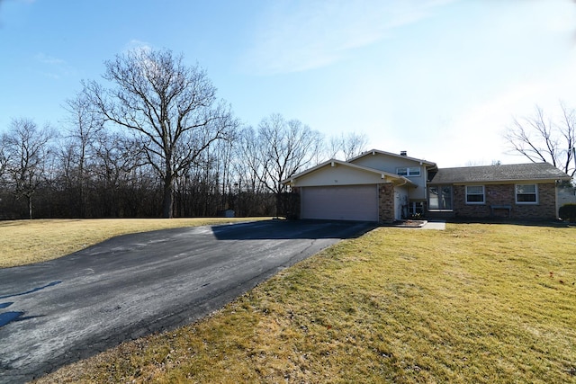 ranch-style house featuring an attached garage, brick siding, aphalt driveway, and a front yard