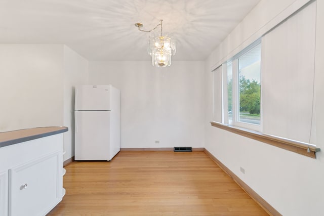 2547 2nd Ave, North Riverside, IL 60546 - unfurnished dining area featuring light wood-style flooring, a chandelier, and baseboards