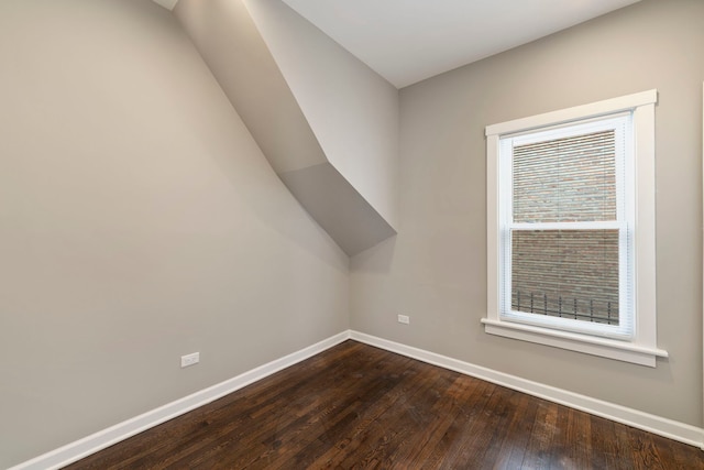 bonus room featuring dark wood finished floors and baseboards