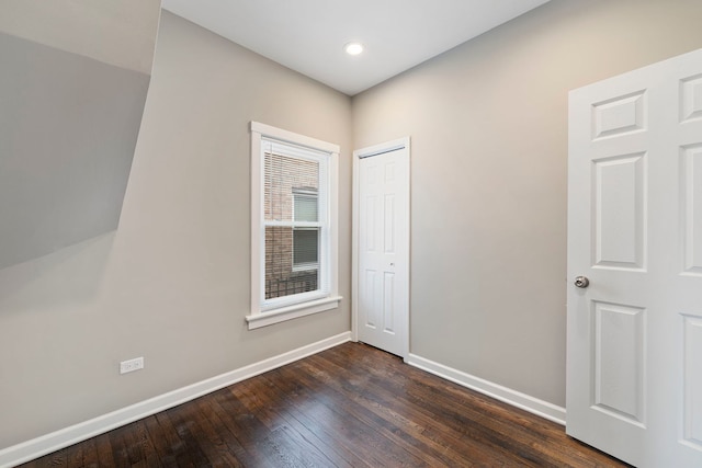 unfurnished room with dark wood-style flooring and baseboards