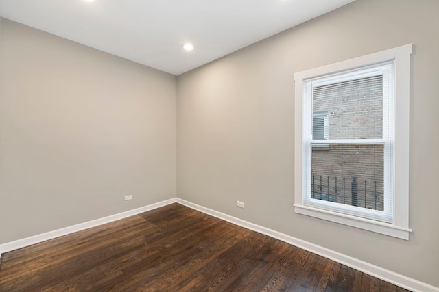 spare room featuring baseboards, dark wood finished floors, and recessed lighting