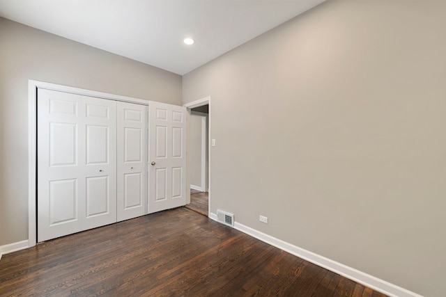 unfurnished bedroom featuring baseboards, visible vents, dark wood-style floors, a closet, and recessed lighting